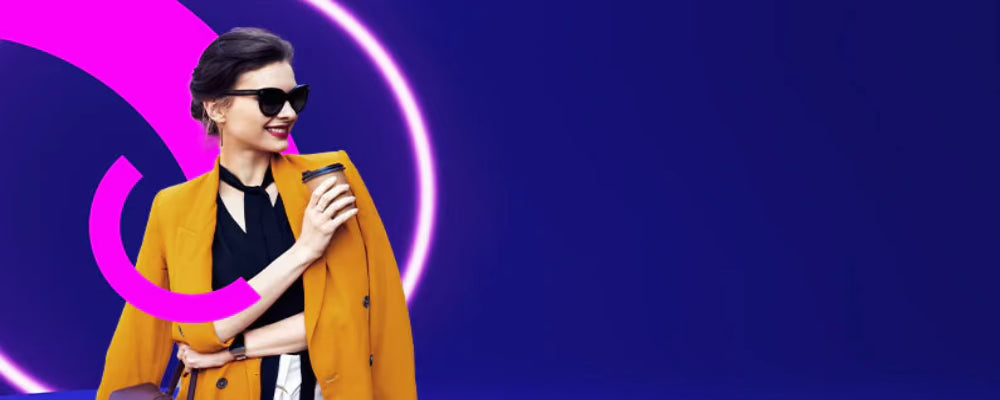 Woman in a mustard yellow coat and sunglasses against a blue and pink abstract background